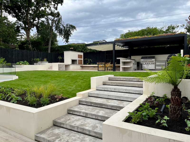 lightweight concrete steps leading to a bespoke outdoor kitchen also crafted from lightweight concrete