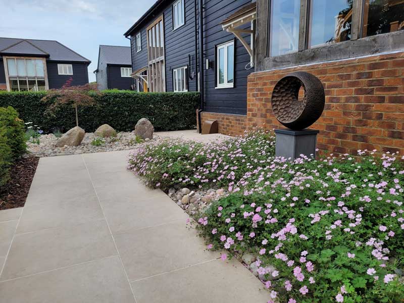 self build property with simple but attractive planting scheme in the front garden