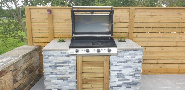 outdoor kitchen with units clad in split face stone tile cladding