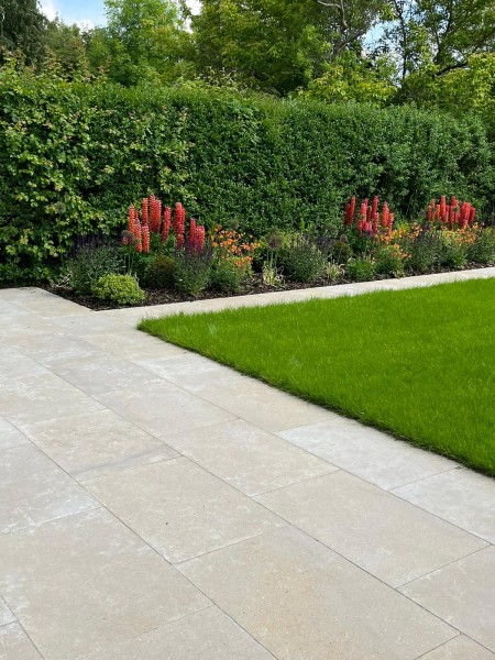 Limestone patio beside well maintained lawn