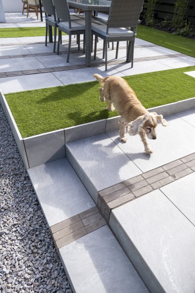 dog stepping onto patio area created using Carlos Grigio Chiario porcelain paving