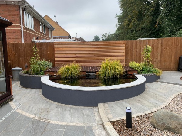 attractive landscaped courtyard garden with cedar fence and bespoke stone planting beds