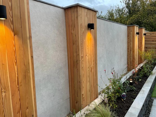 garden wall with timber pillars alternating with panels of stone tile cladding