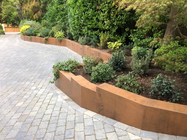 limestone setts adjacent to low garden wall with corten steel porcelain cladding