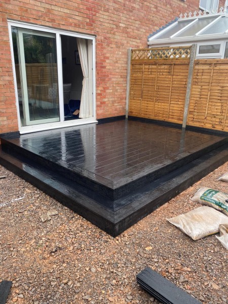 Small decking area beside patio doors, created using London hollow composite decking in charcoal colour way