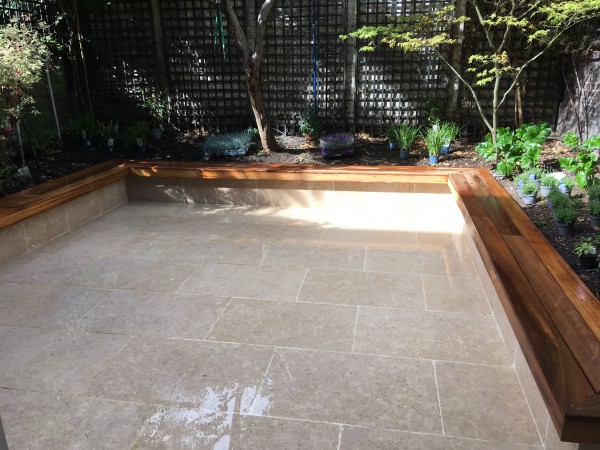 Large pearl beige limestone patio edged with timber