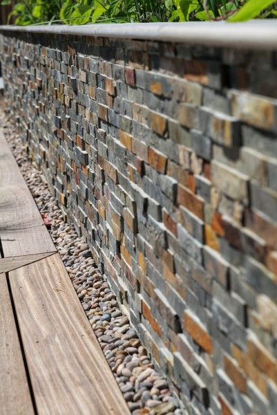 garden wall clad with split face stone tile cladding