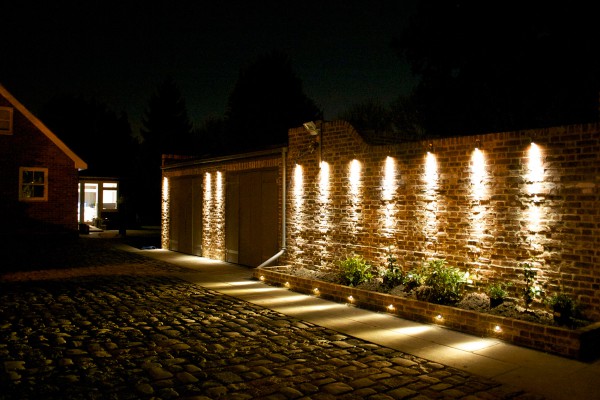 garden wall with plants illuminated using wall mounted down lights