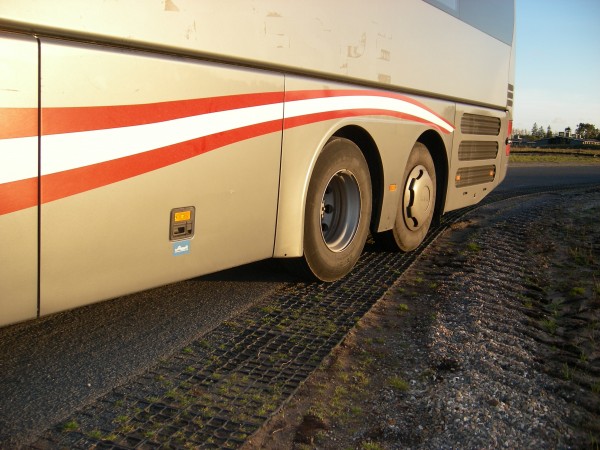 rear wheel of bus driving over ground reinforcement grids