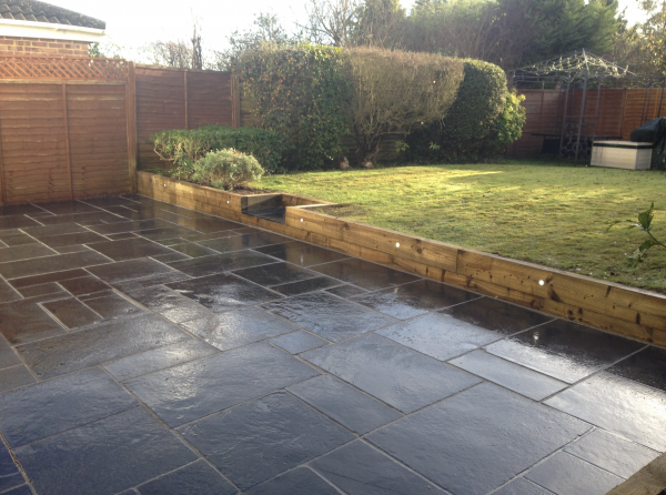 Black limestone patio with views across a large lawn