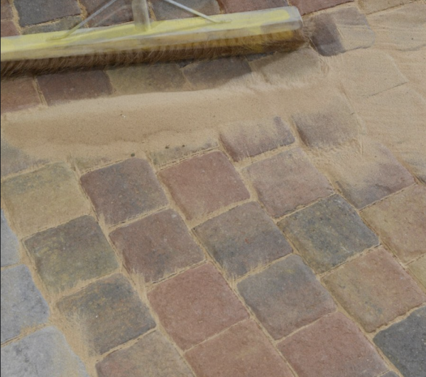 Kiln dried sand being used on paving joints