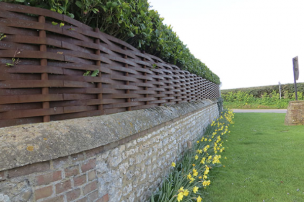 Woven fencing atop garden walling