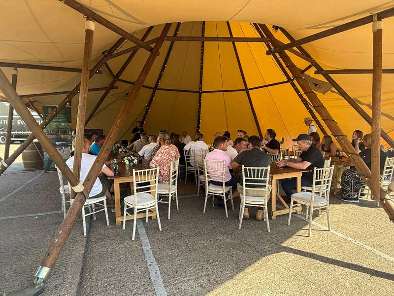 garden designers and landscapers enjoying a meal beneath a huge teepee at Arbour Landscape Solutions summer event 2025