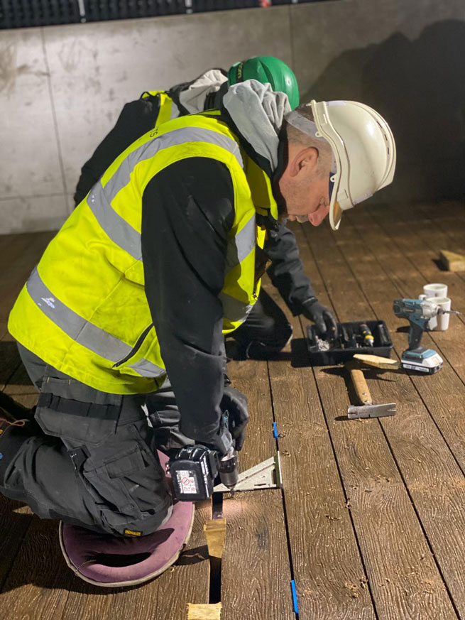 landscaper installing solid composite decking boards