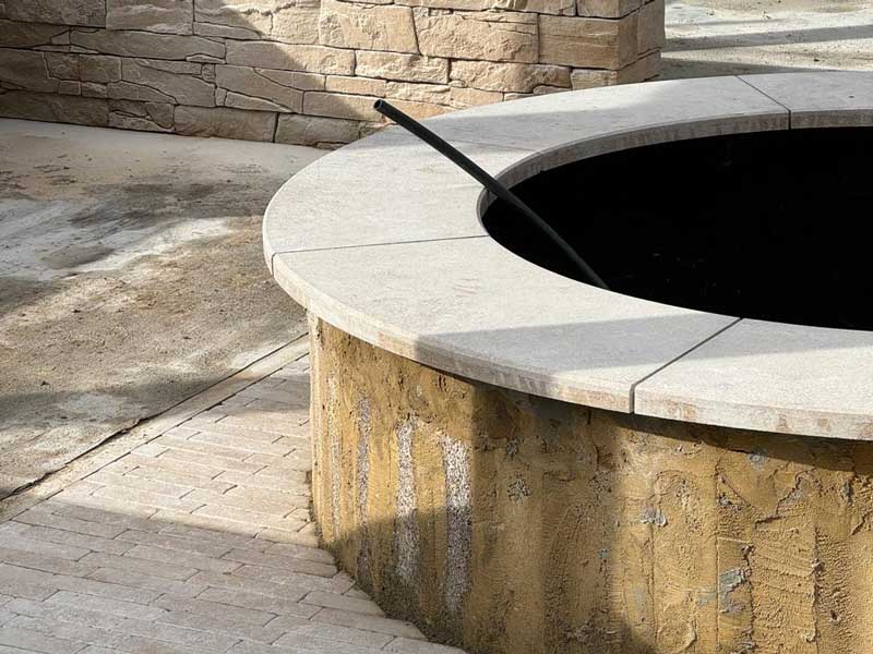 curved coping stones with an elegantly profiled edge sit atop a circular stone built planter