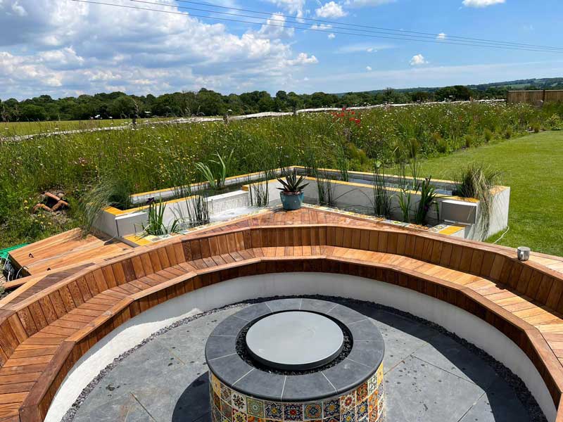 moroccan inspired firepit with views across wildflower meadows to woodland beyond