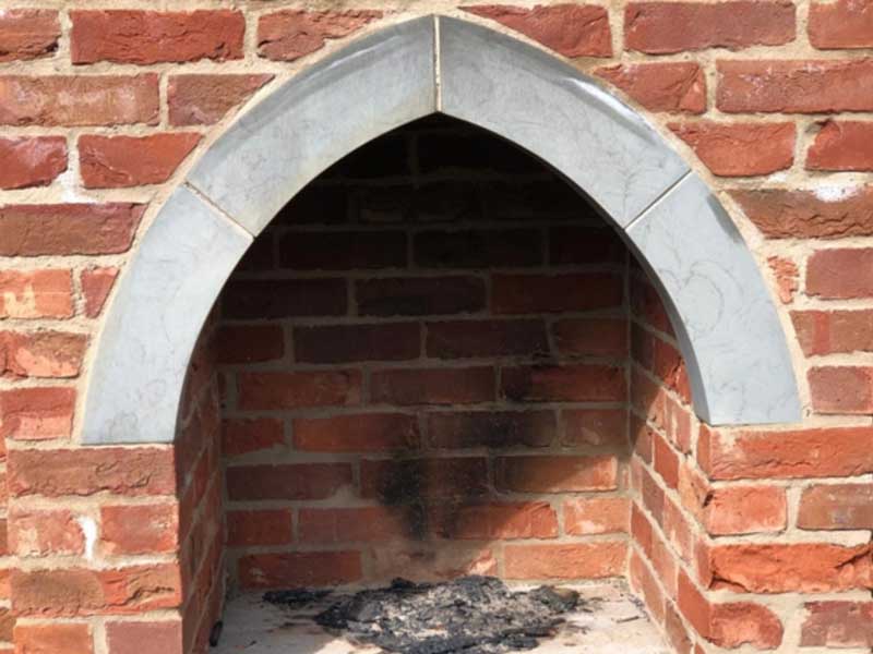 Bespoke yorkstone archway set into a brick made pizza oven