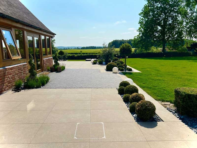 large patio built by Outsiders Landscaping using porcelain pavers from Arbour Landscape Solutions