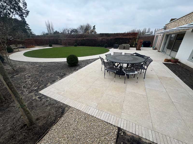 attractive back garden with large natural  limestone patio adjacent to the house