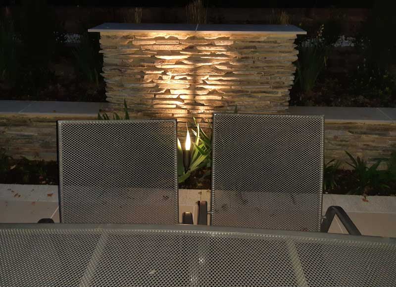 outdoor lighting accentuating the texture of a natural stone wall