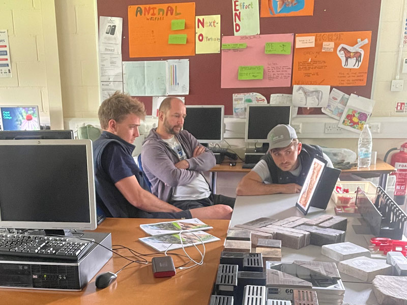 three landscaping students intensly watching an online demonstration