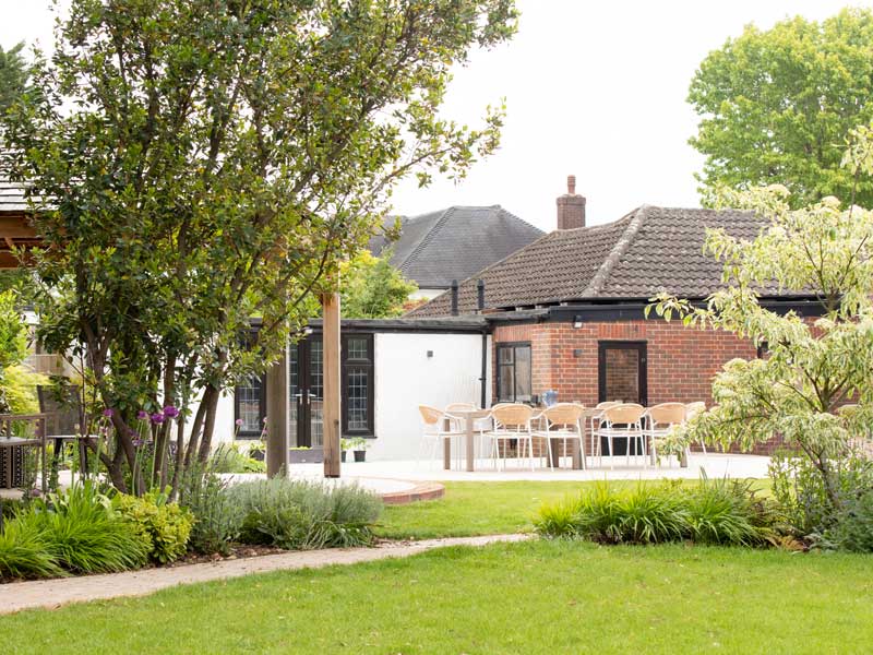 mid 20th century house viewed from a beautifully verdant landscaped back garden