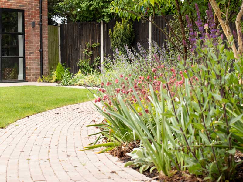 naturalistic planting plan beside a curved path built using limestone slim setts
