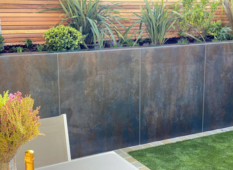 Elegant raised bed beautifully clad with porcelain cladding sheets in cool steel