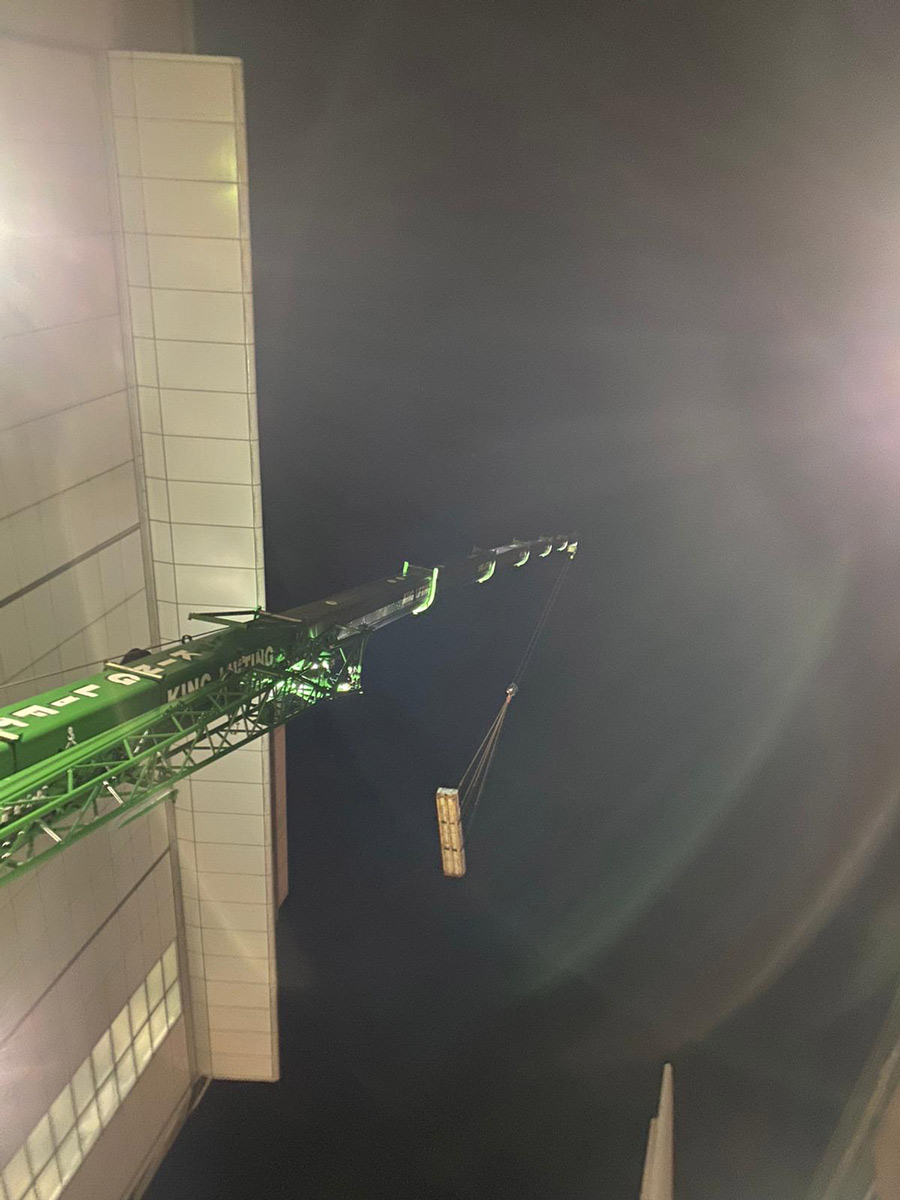 landscaping materials being lifted onto roof by crane