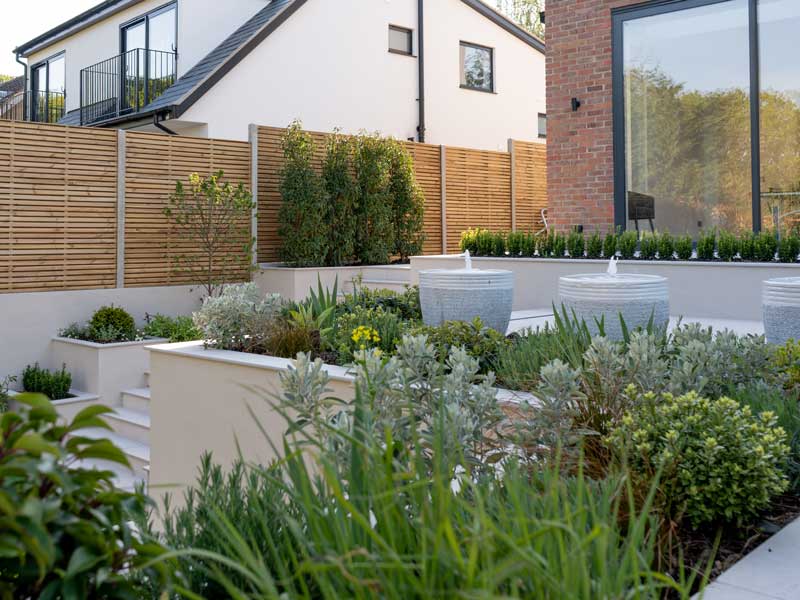 modern back garden with light coloured steps and raised beds