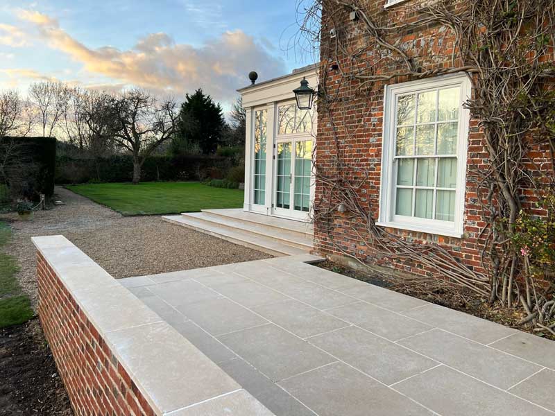 attractive natural limestone patio adjacent to georgian mansion with garden room to the side