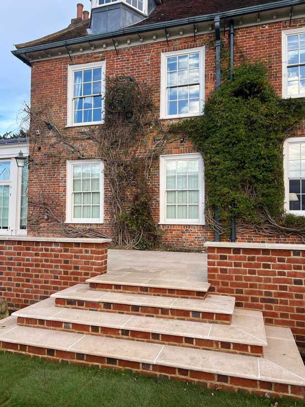 georgian style mansion with impressively landscaped steps leading to wrap around terrace