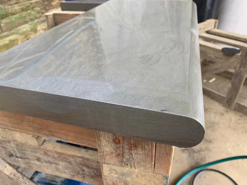 Stone step raised up on a trellis table to show the newly bullnosed edge