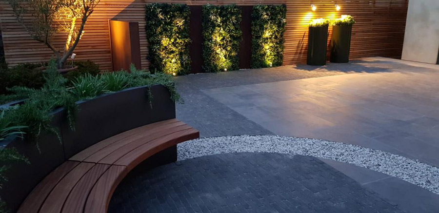 uplit green walls in a courtyard garden at dusk