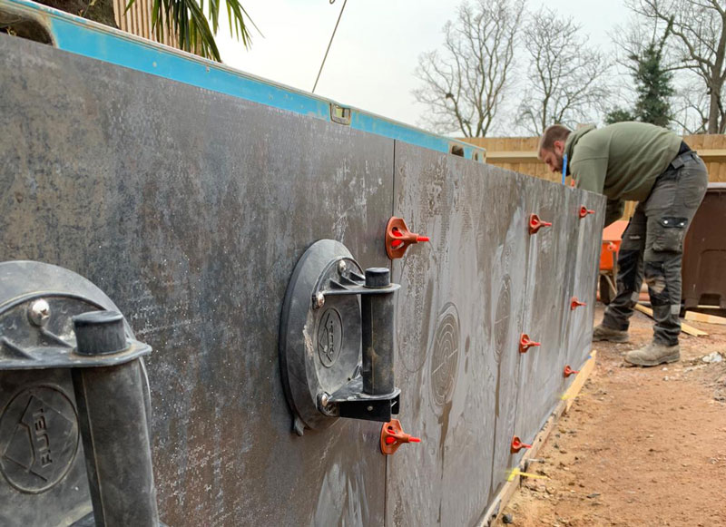 landscaper applying x-tech porcelain cladding to a retaining wall