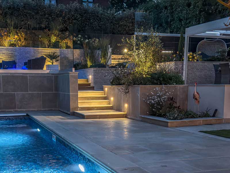 garden with swimming pool softly lit for evening ambience