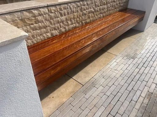 Split-faced sawn limestone cladding, render and copings surrounding a bench.