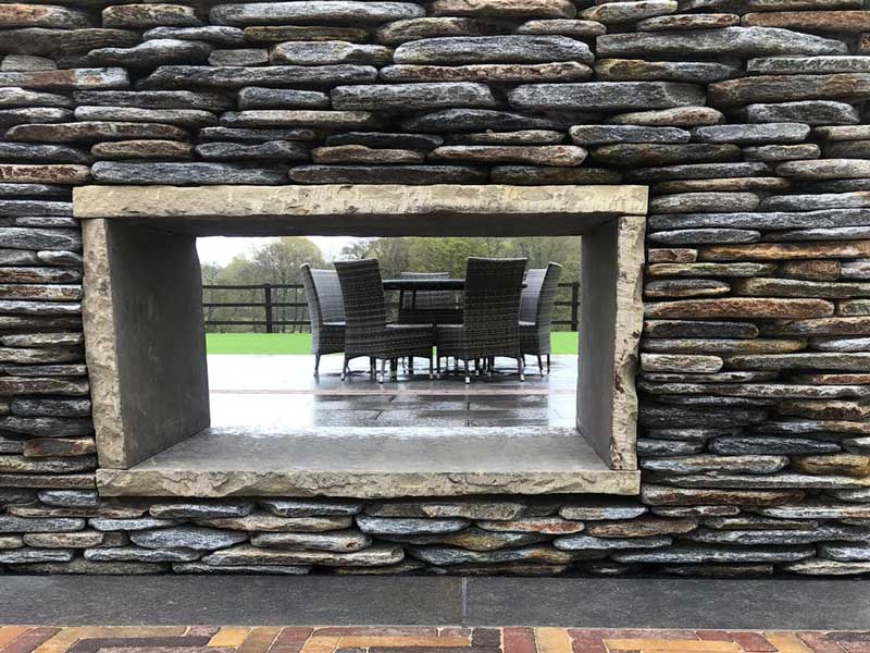 amazing outdoor fireplace built by Manor Prestige Landscapes using paddlestones from Arbour Landscape Solutions