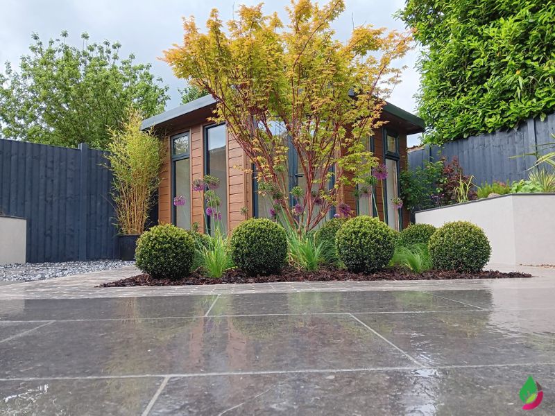 meli dark grey egyptian limestone patio with attractive timber summerhouse