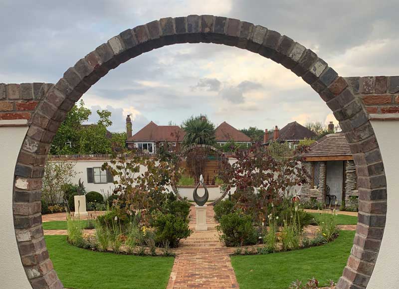 moon gate with view over secret garden by Jack Dunkley