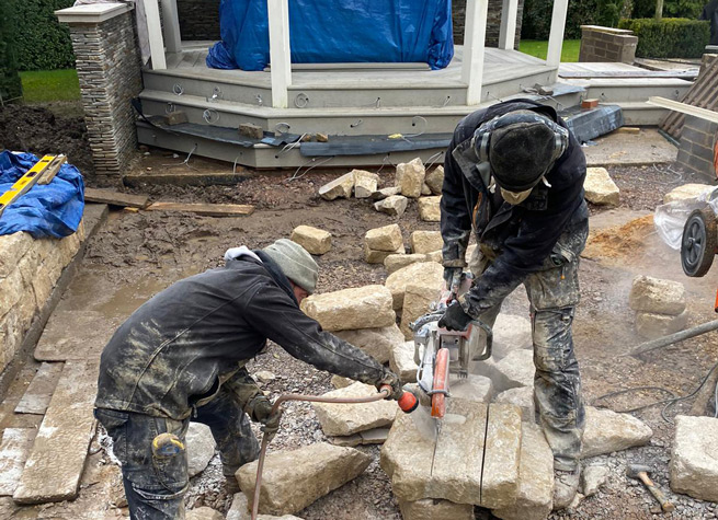 landscapers cutting stone