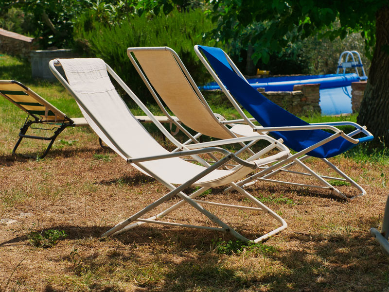 deck chairs sitting on a scorched brown lawn in midsummer