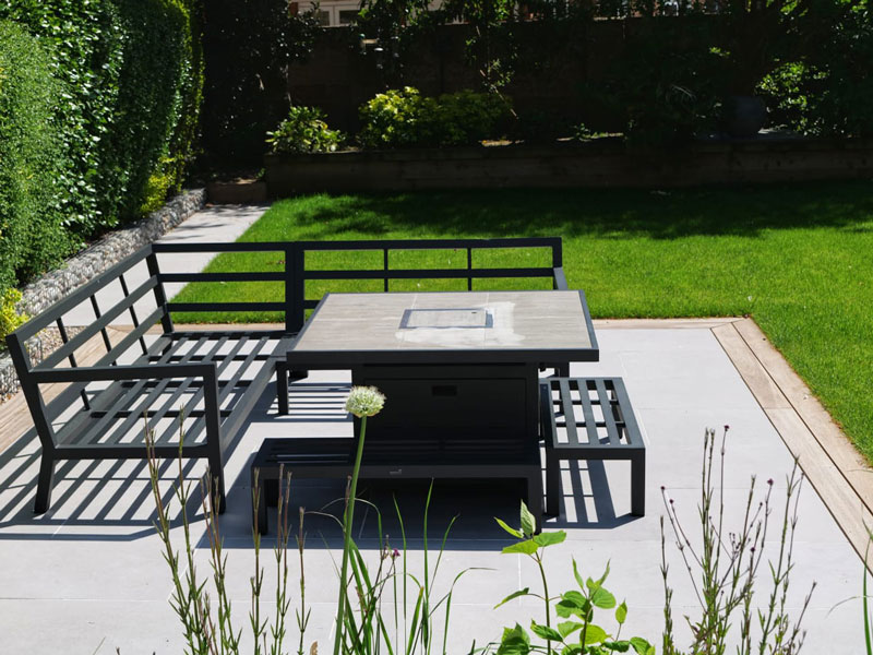 small patio with surrounding lawn and hedges