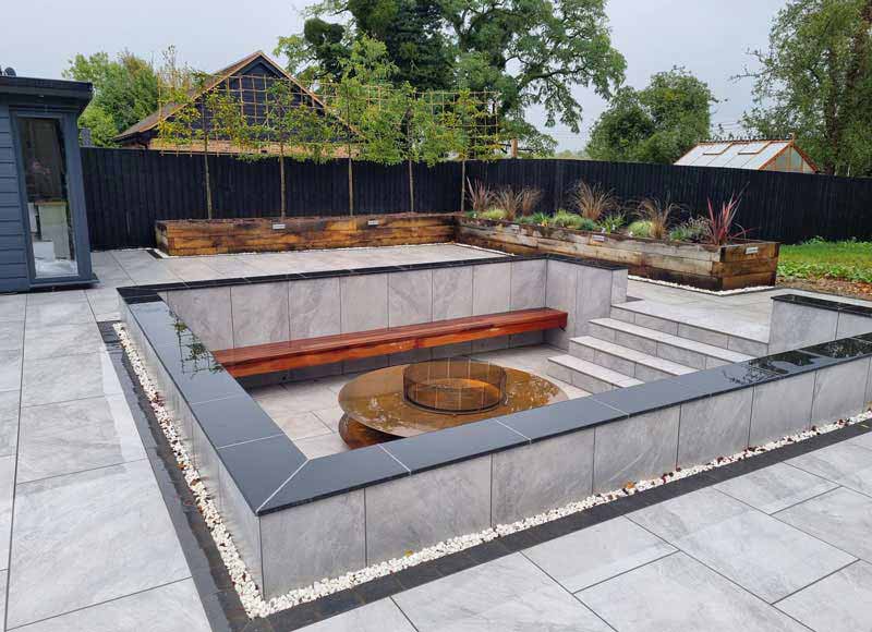 Jura Grey Porcelain Paving in a modern garden with sunken firepit