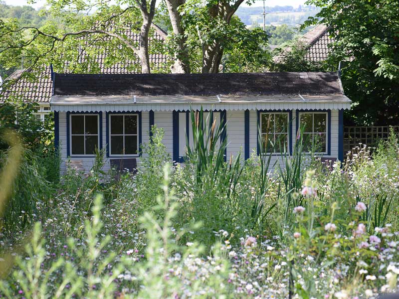 garden shed disguised as a victorian railway station with painted white walls