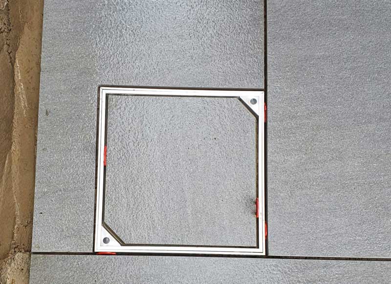 crisply positioned recessed manhole cover in limestone patio