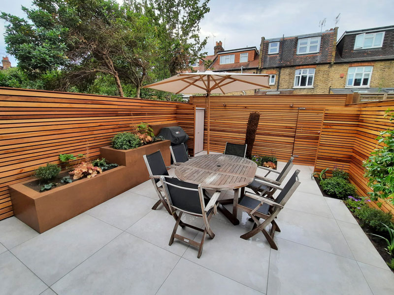 outdoor seating area in a small garden with beautiful cedar fencing