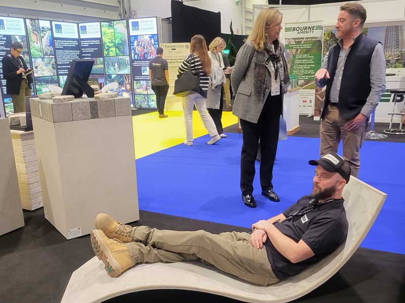 landscaper relaxing on lounger with Anna Roochove and Andrew Barringer in the background