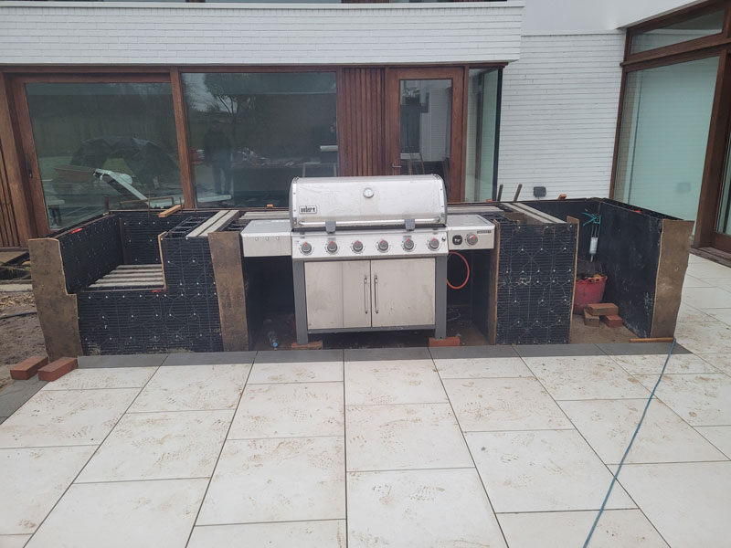 outdoor kitchen under construction using solid wall block system from Arbour Landscape Solutions