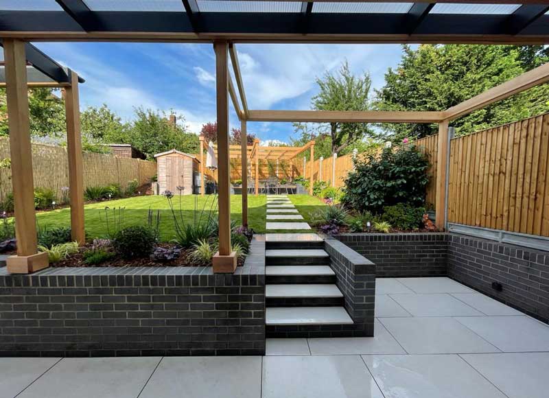 family garden with covered patio and stepping stones leading across a wide lawn